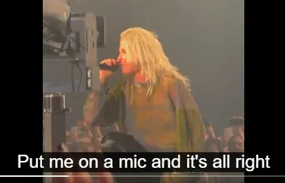 A video still subtitled Put me on a mic and it's all right, the singer caught mid-line