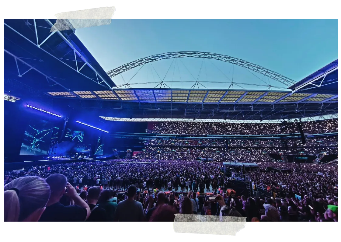 The full stadium bowl in daylight under the arch, the crowd packed to the back of the stands