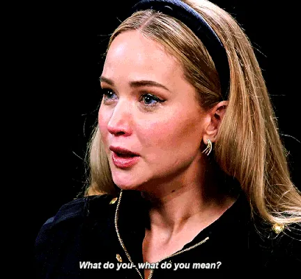 A film still of a woman in a headband mid-sentence, subtitled: What do you- what do you mean?