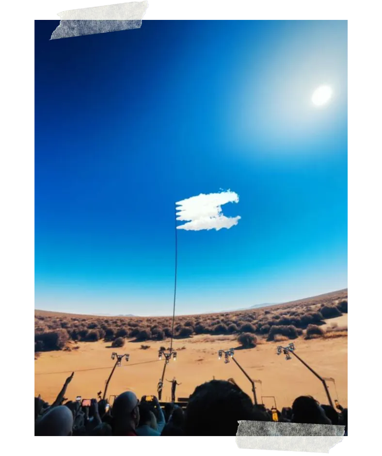 The Sphere's screen filled with a desert under a blue sky and one small cloud, the crowd silhouetted below