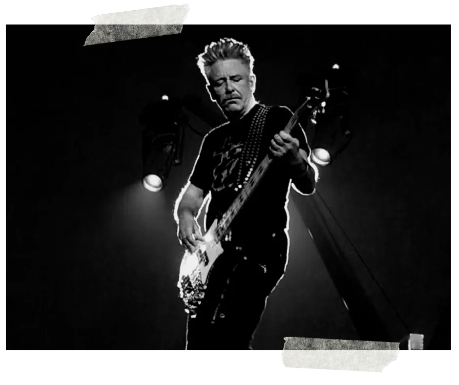 Black and white: a bassist leaning into his instrument under a single spotlight